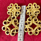 Front view of vintage gold-tone Yves Saint Laurent statement drop earrings displayed on a red background, with a measuring tape showing approximately 8 cm length