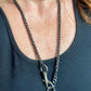 Worn by model close up on Vintage Saint Laurent upcycled necklace featuring a dark gunmetal chain with original lock and key charm pendant, repurposed from a Saint Laurent keychain In a different style 