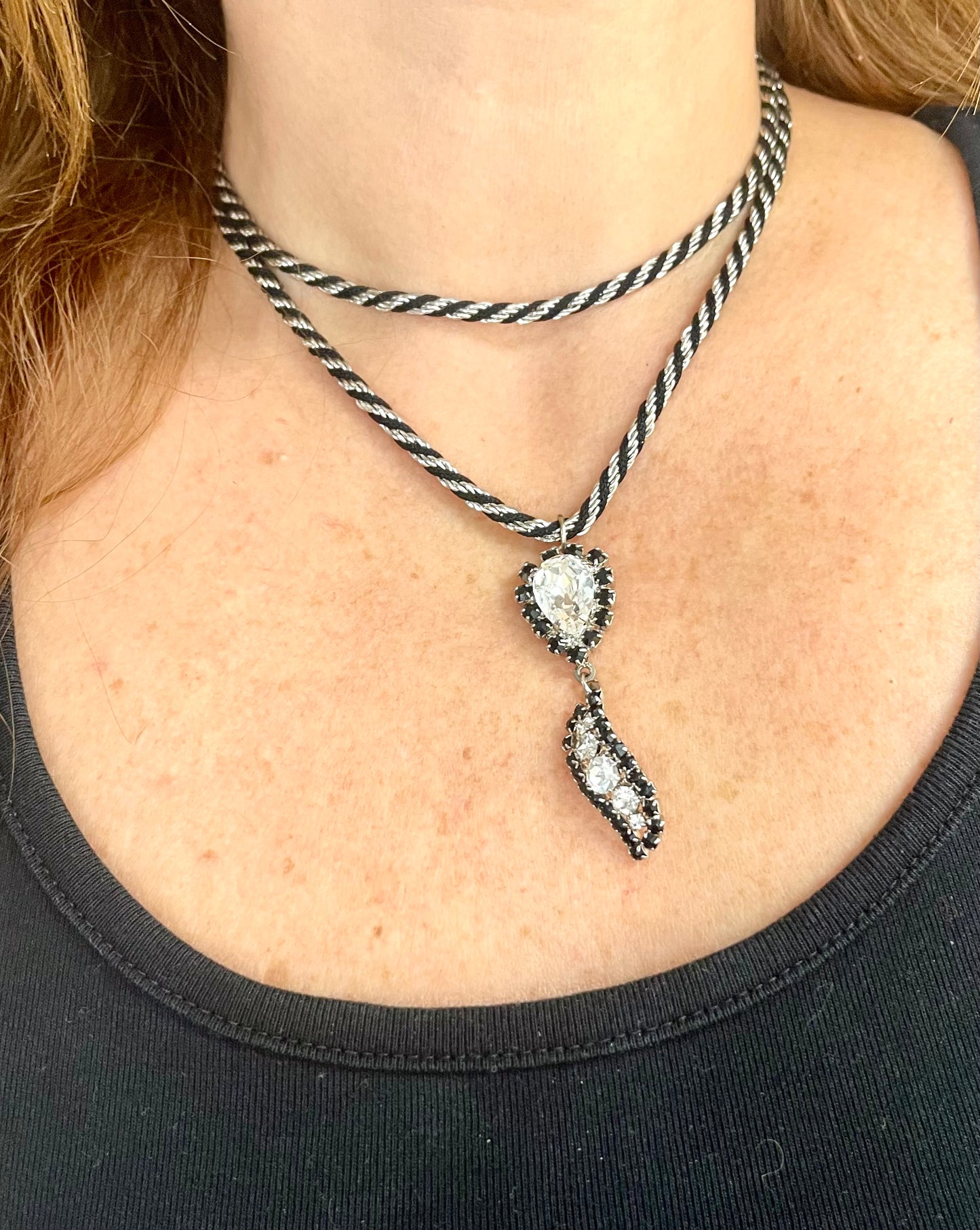 Vintage Trifari silver-tone rope necklace with black cord featuring an attached Christian Dior crystal pendant worn by model