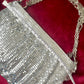 Width measurement of the One of a kind handmade Paco Rabanne repurposed silver pixel mesh bag using a measuring tape on red background 