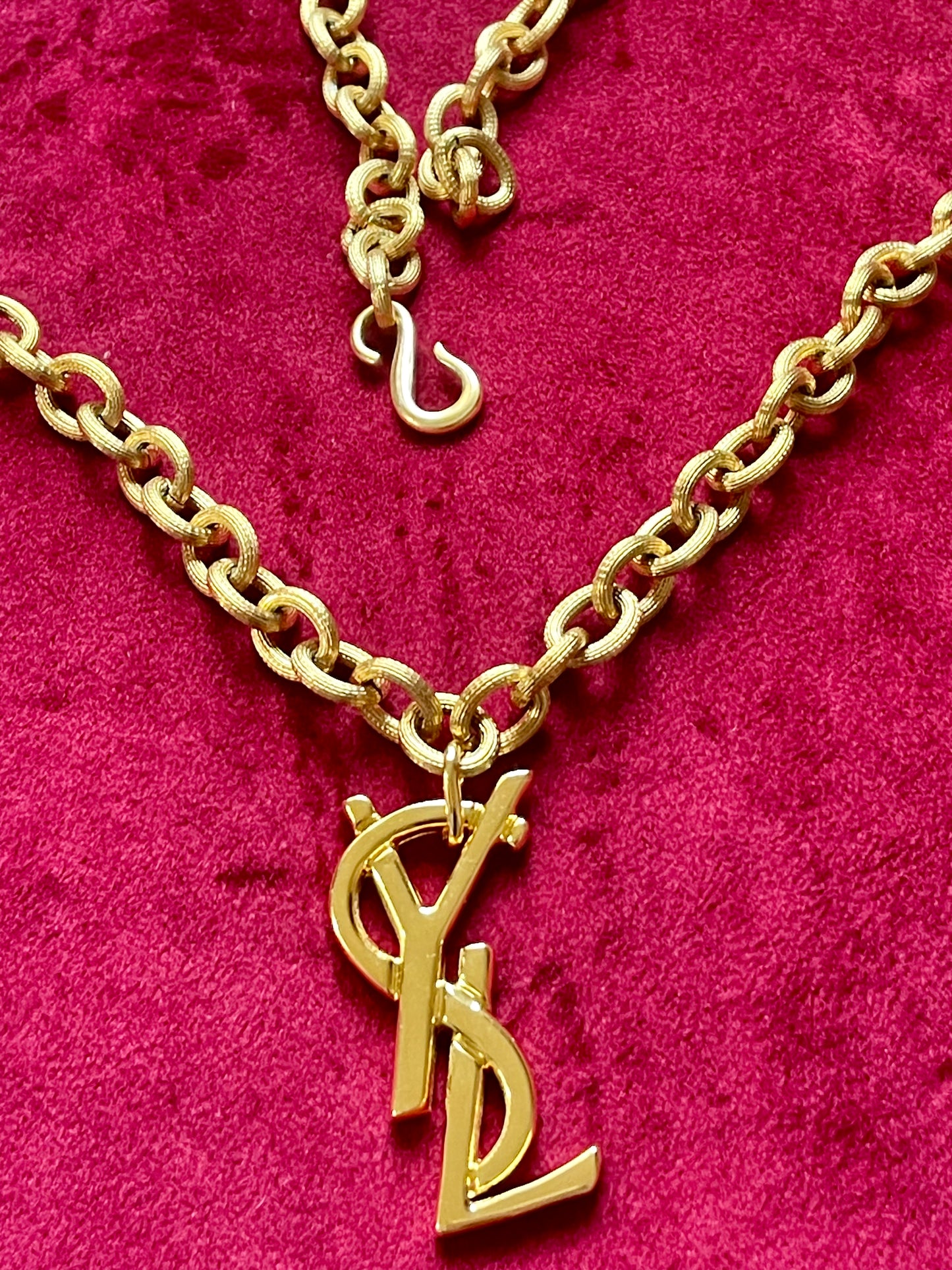 Authentic YSL oversized gold logo bag charm pendant repurposed into a long chain necklace, close-up detail
