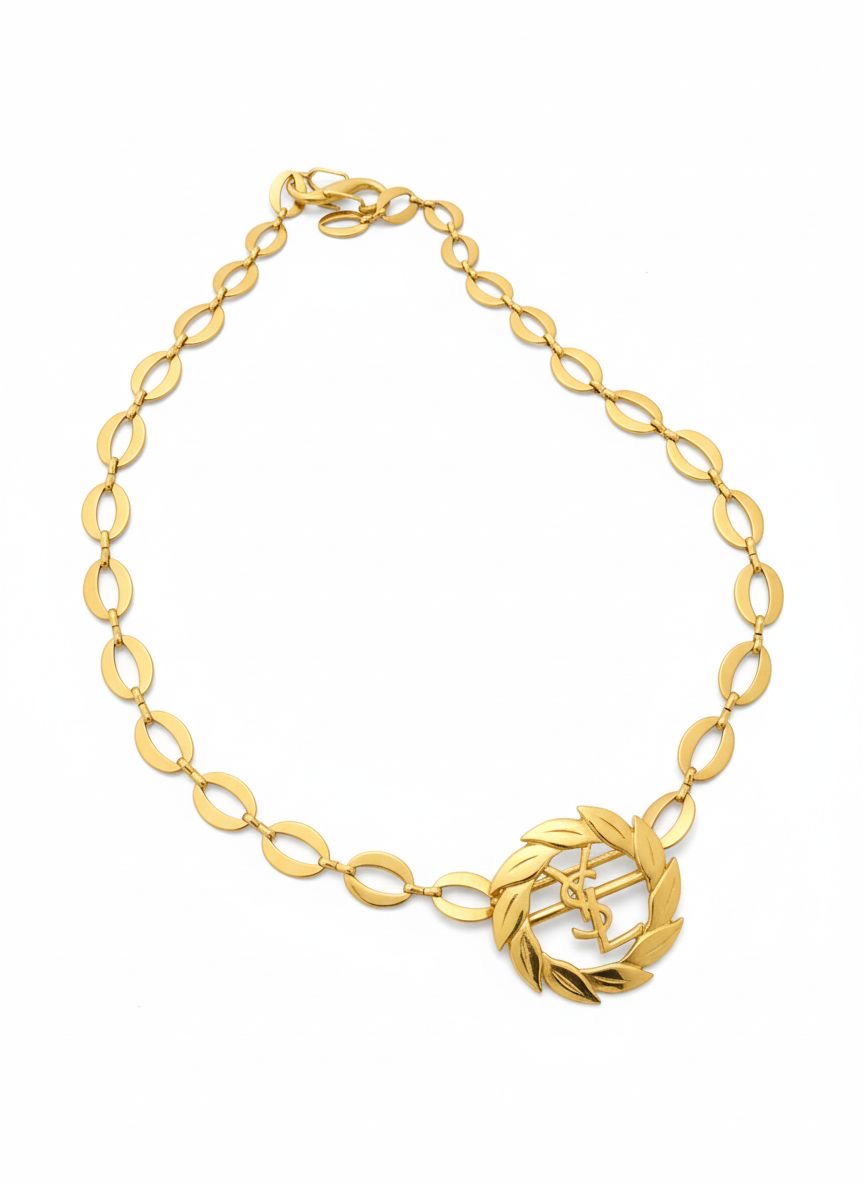 Top view of a refurbished vintage YSL laurel wreath pendant mounted on a gold-plated stainless steel necklace, with adjustable hoop links and a slightly lighter-toned closure.
