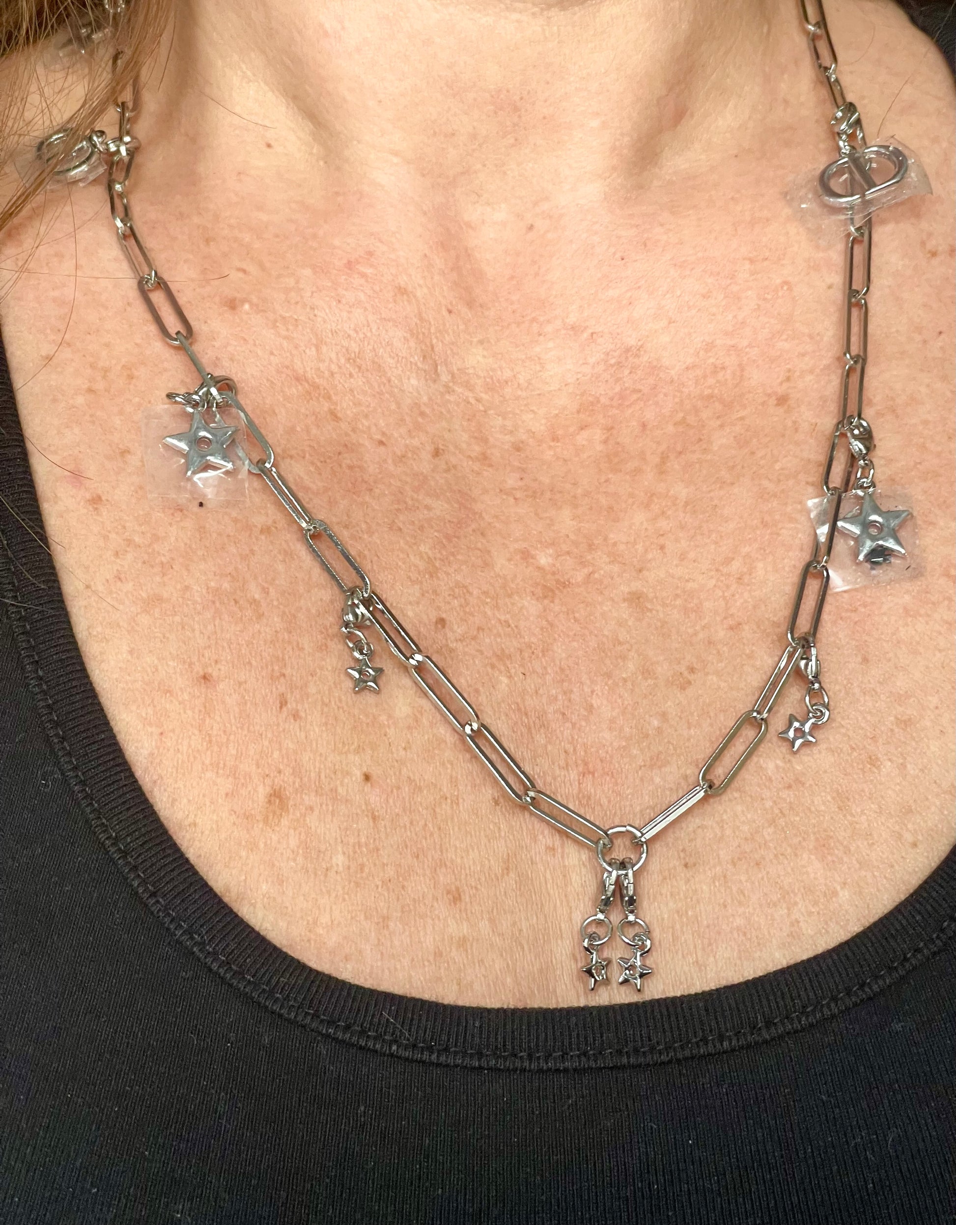 Worn by model on single upcycled Dior Beauté phone charm necklace with removable silver-tone charms