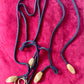 One of a kind Necklace with leaf-like pendants and Yves Saint Laurent scarf pendant on a red fabric background