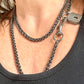 Worn by model a different style Vintage Saint Laurent upcycled necklace featuring a dark gunmetal chain with original lock and key charm pendant, repurposed from a Saint Laurent keychain 
