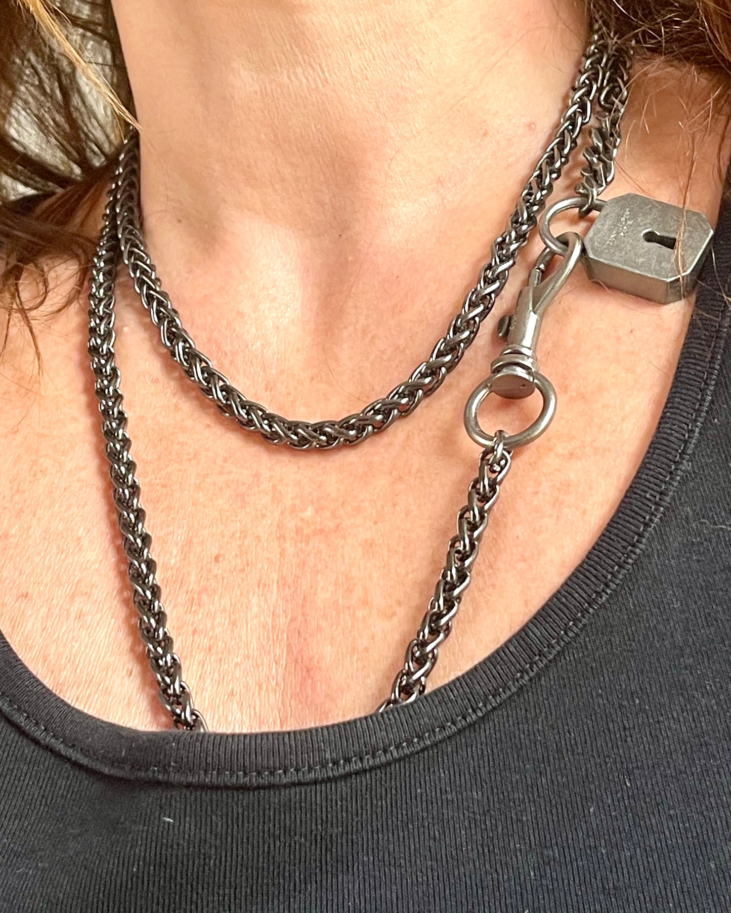 Worn by model a different style Vintage Saint Laurent upcycled necklace featuring a dark gunmetal chain with original lock and key charm pendant, repurposed from a Saint Laurent keychain 