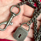 Backside close up on Vintage Saint Laurent upcycled necklace featuring a dark gunmetal chain with original lock and key charm pendant, repurposed from a Saint Laurent keychain