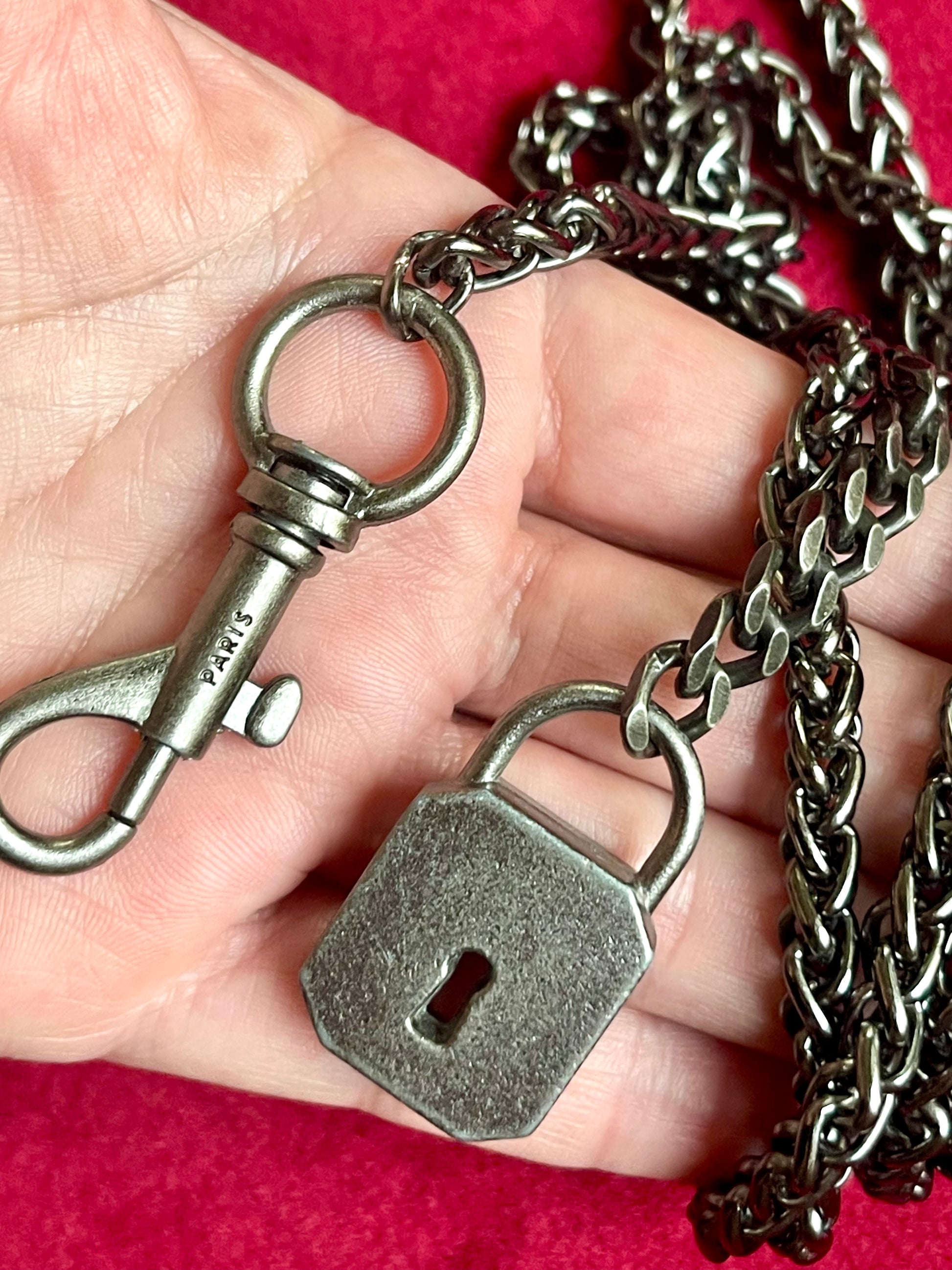 Backside close up on Vintage Saint Laurent upcycled necklace featuring a dark gunmetal chain with original lock and key charm pendant, repurposed from a Saint Laurent keychain