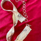 Over all view vintage silver Paco Rabanne mesh belt on red velvet background showing two sides with closure clasp and adjustable hoops 