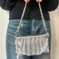 Model holding by hand the One of a kind handmade Paco Rabanne repurposed silver pixel mesh bag