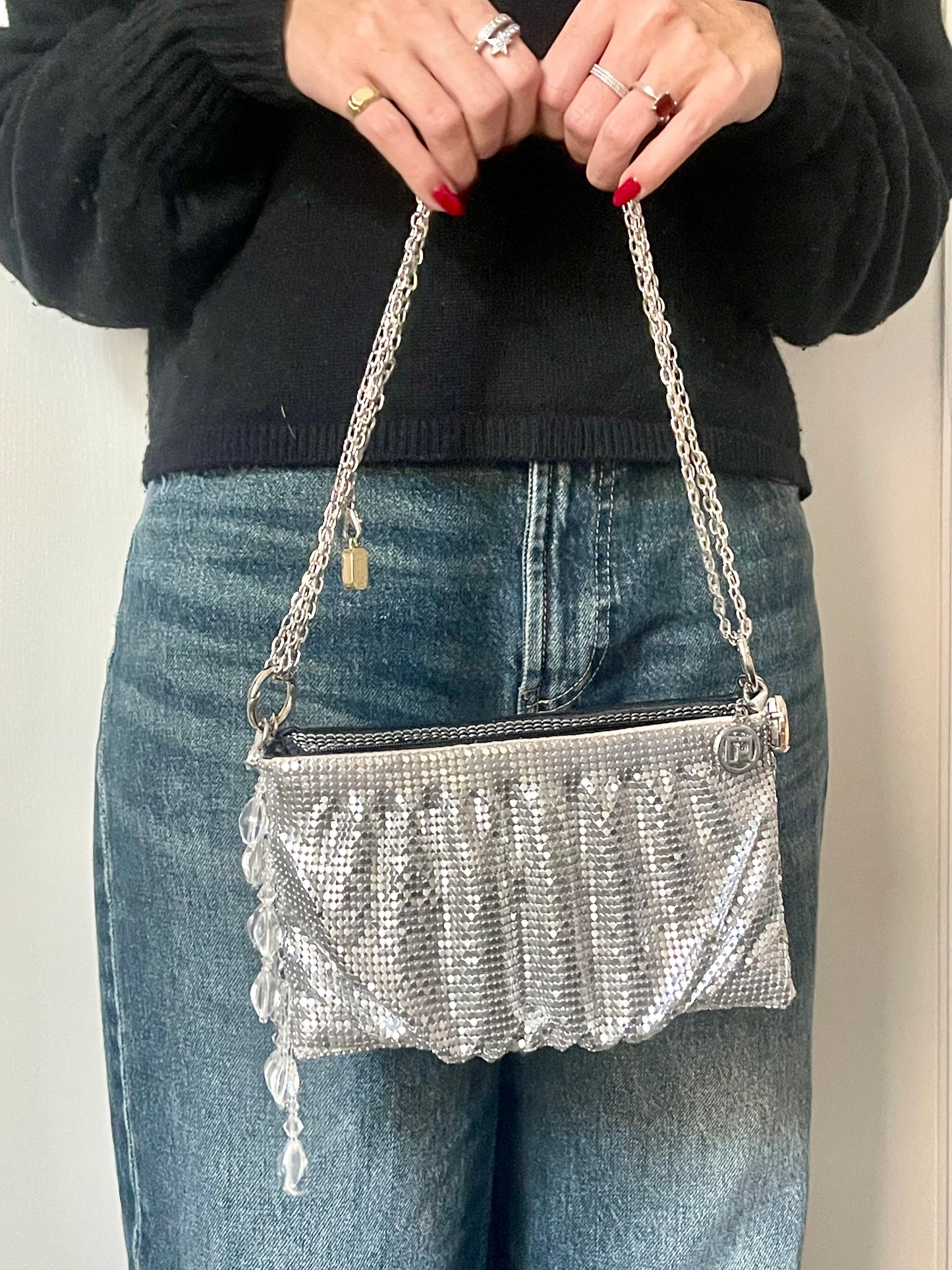 Model holding by hand the One of a kind handmade Paco Rabanne repurposed silver pixel mesh bag
