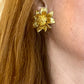 Gold sunflower vintage Orena Paris earring worn by a person with blonde hair.