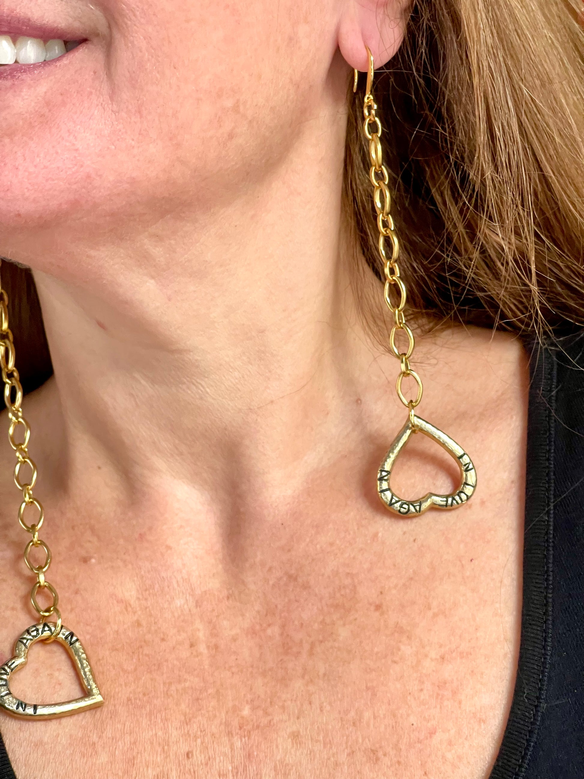 Side view of gold-plated YSL earrings worn