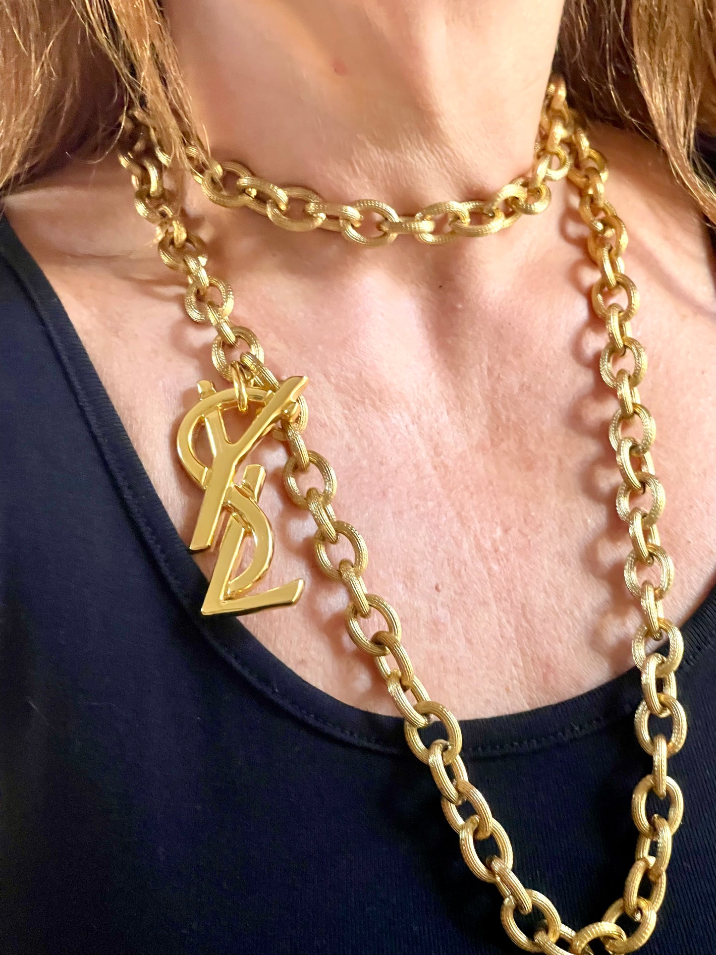 Worn by model Upcycled vintage Yves Saint Laurent gold-plated logo pendant on long stainless steel chain necklace showing different styles 