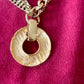 Backside view of Yves Saint Laurent vintage 80s pendant  showing hallmark signature YSL made in France on red background 