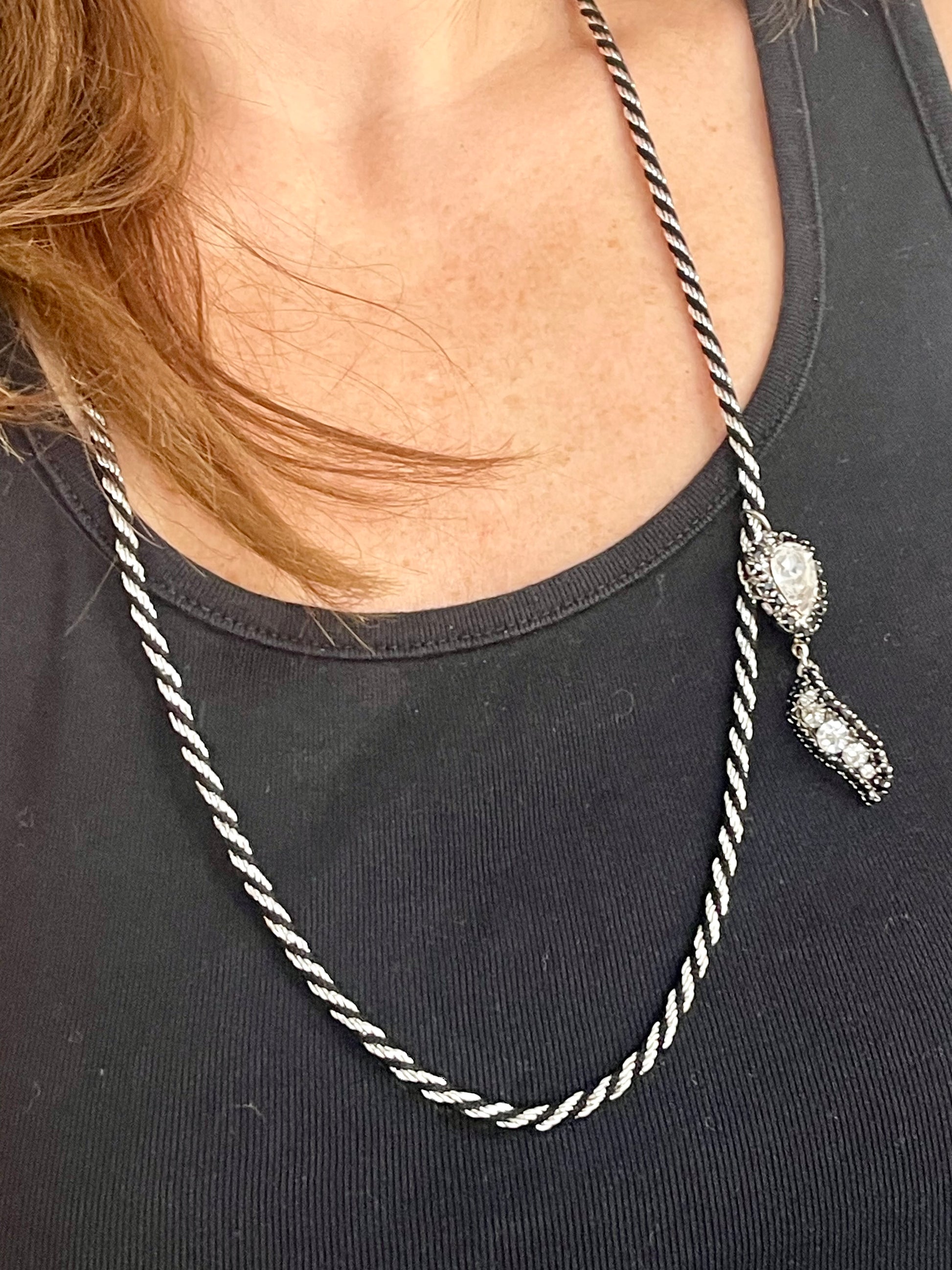 Different style worn by model Vintage Trifari silver-tone rope necklace with black cord featuring an attached Christian Dior crystal pendant 