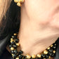 On model Yves Saint Laurent vintage gold tone cross clip-on earrings from the 1980s, showing rounded gold domes and square-cut center stones