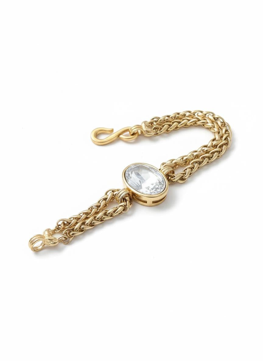 Yves Saint Laurent gold chain bracelet with a clear gemstone on a white background