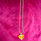 Elegant gold-tone chain with bright orange resin pendant YSL necklace on pink background 
