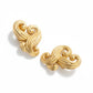 Vintage Nina Ricci swirly heart earrings in matte gold plated metal, signed Nina Ricci Paris, 1990s design on a white background 