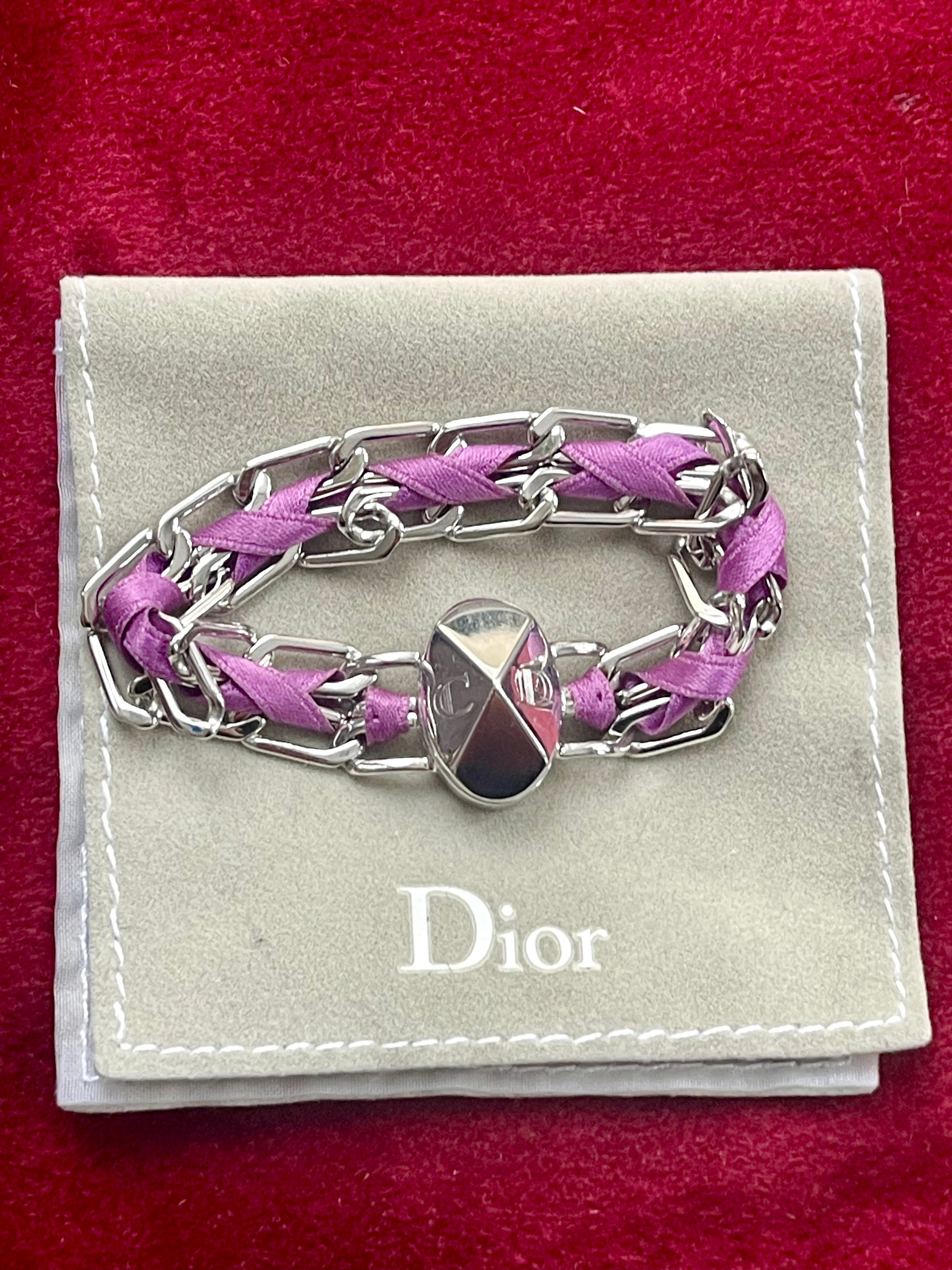 Dior Gourmet Purple braided bracelet with silver chain on a Dior branded pouch against a red background