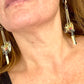 Close up YSL Earrings worn on a model’s ear showing medium weight and long chain style