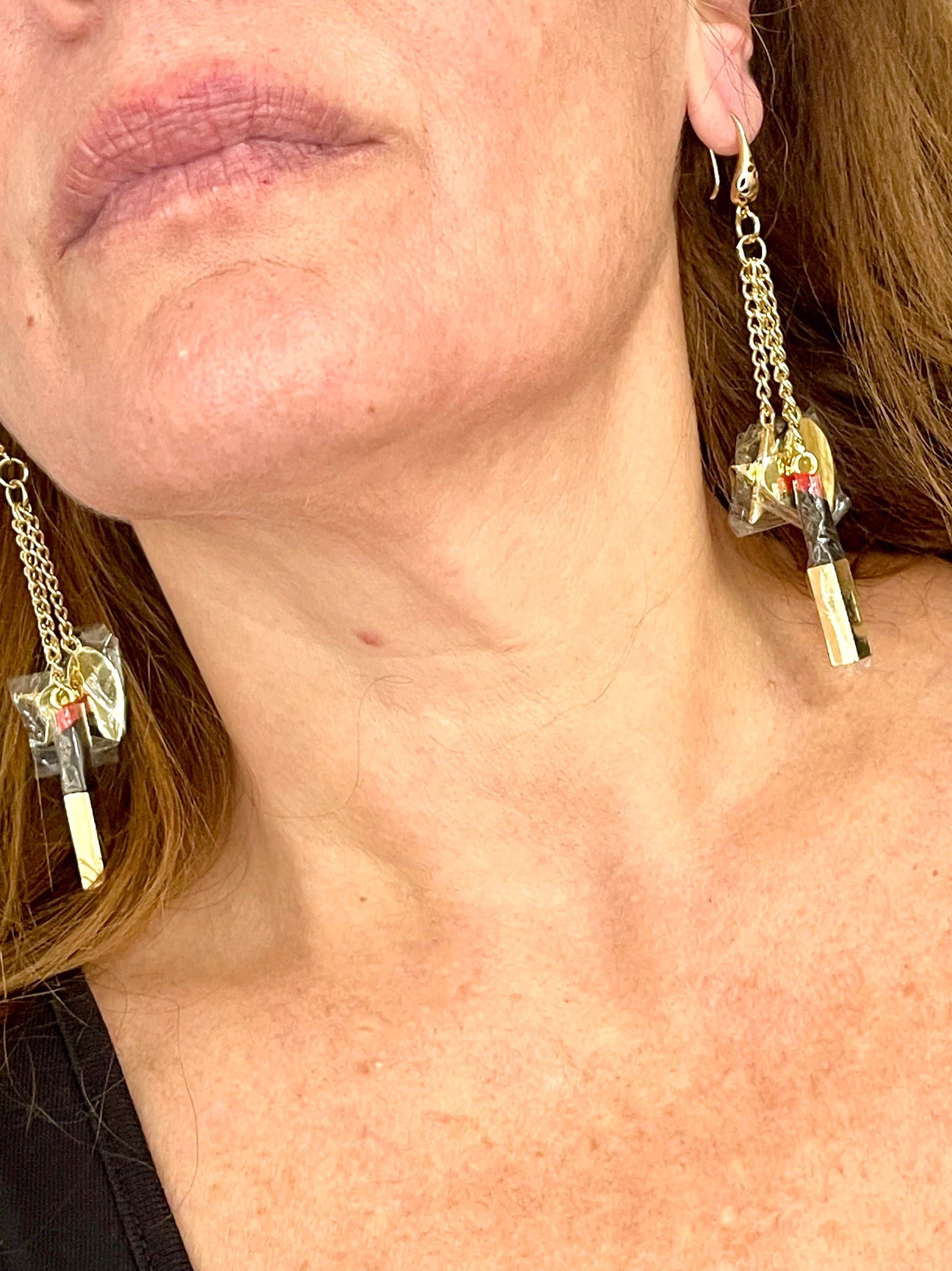 Close up YSL Earrings worn on a model’s ear showing medium weight and long chain style