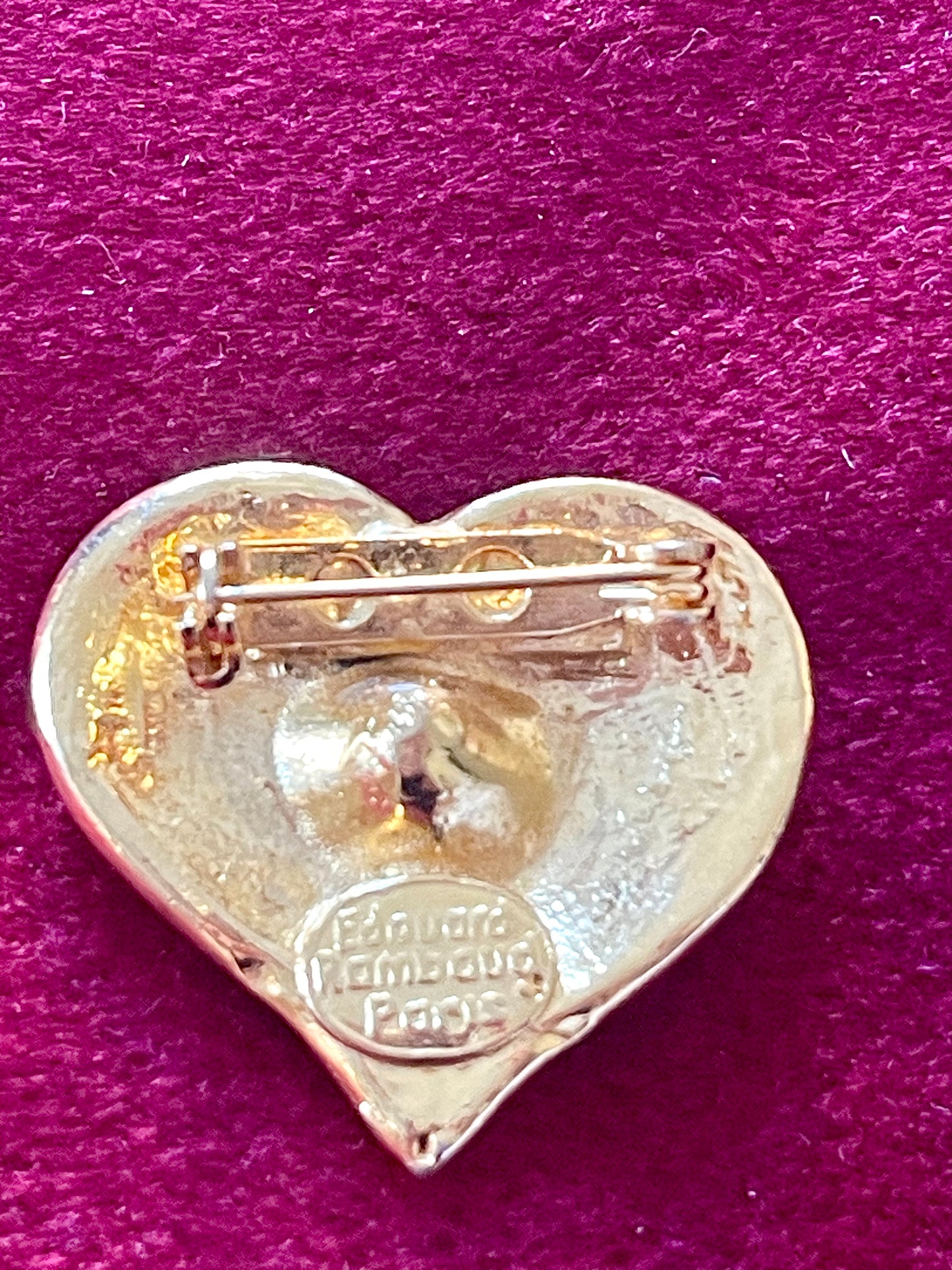 Back of brooch showing signature “Édouard Rambaud Paris” on a red background 