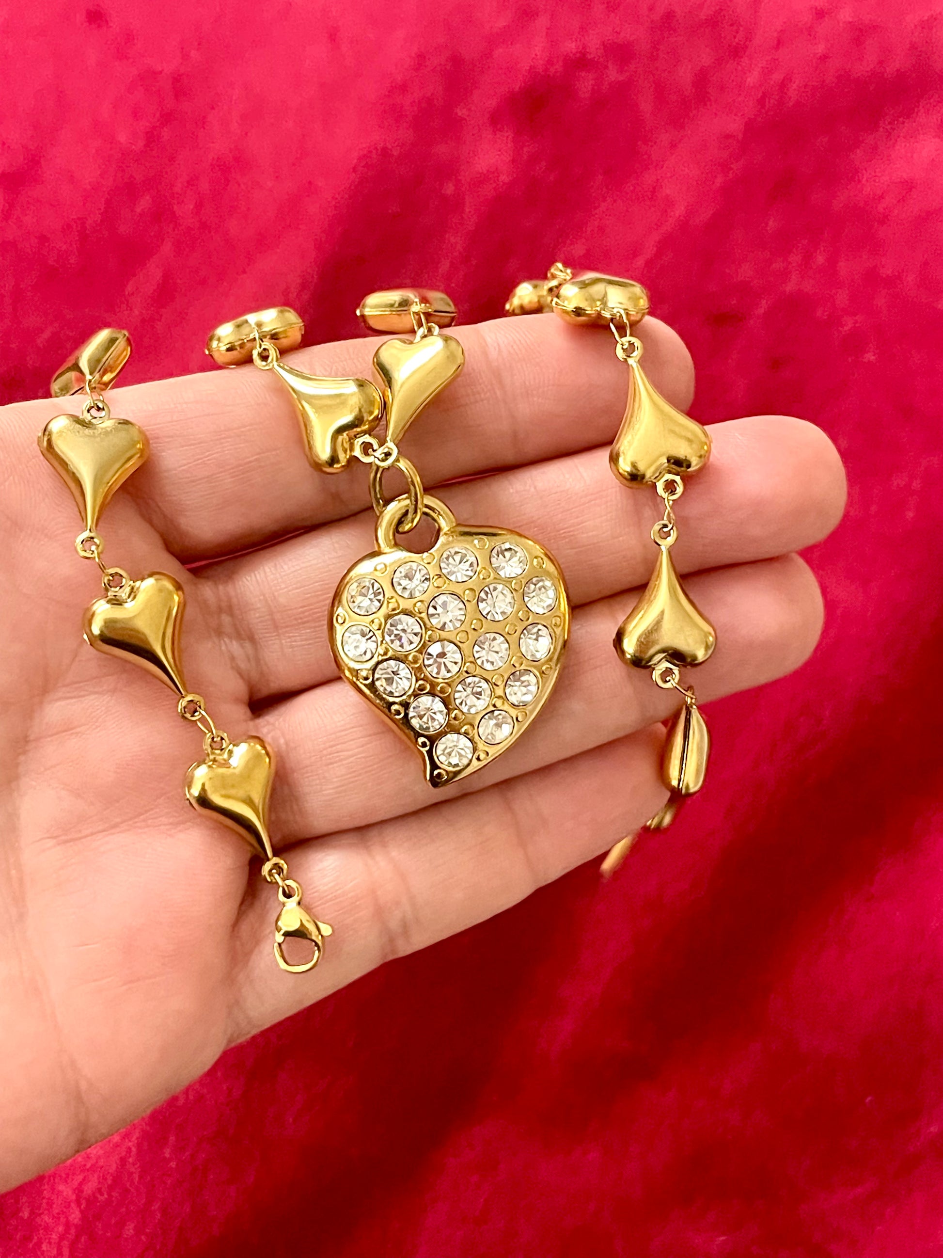 Vintage YSL rhinestone heart pendant necklace held in hand showing size and gold chain detail, Valentine's Day gift