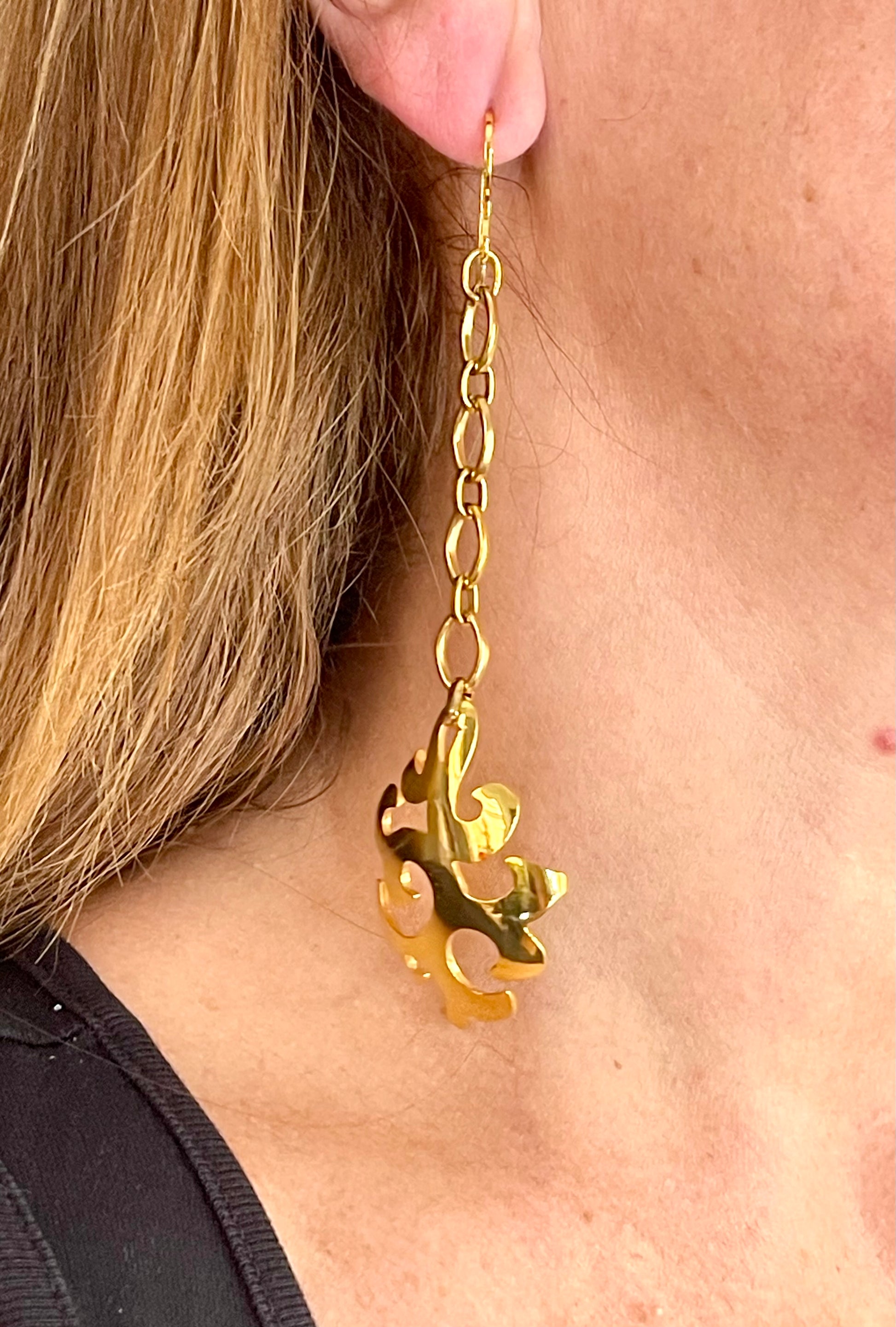 Close up Yves Saint Laurent long drop earrings photographed from different angle