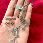 Showing original design of upcycled Dior Beauté phone charm necklace with removable silver-tone charms on palm of hand with a red background 
