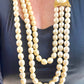 Vintage Yves Saint Laurent multi-strand pearl necklace layered with shorter leather necklace for a sophisticated, fashion-forward look.