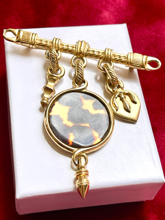Yves Saint Laurent vintage gold brooch with leopard-print center, photographed on a clean white background.