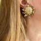 Vintage Yves Saint Laurent Gold sun-shaped earrings with rhinestones  worn by a model with blonde hair