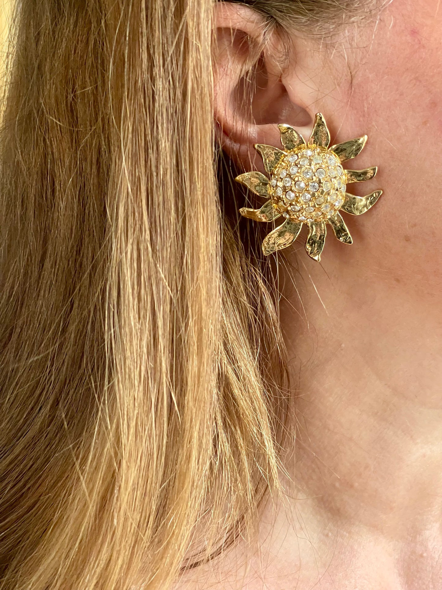 Vintage Yves Saint Laurent Gold sun-shaped earrings with rhinestones  worn by a model with blonde hair