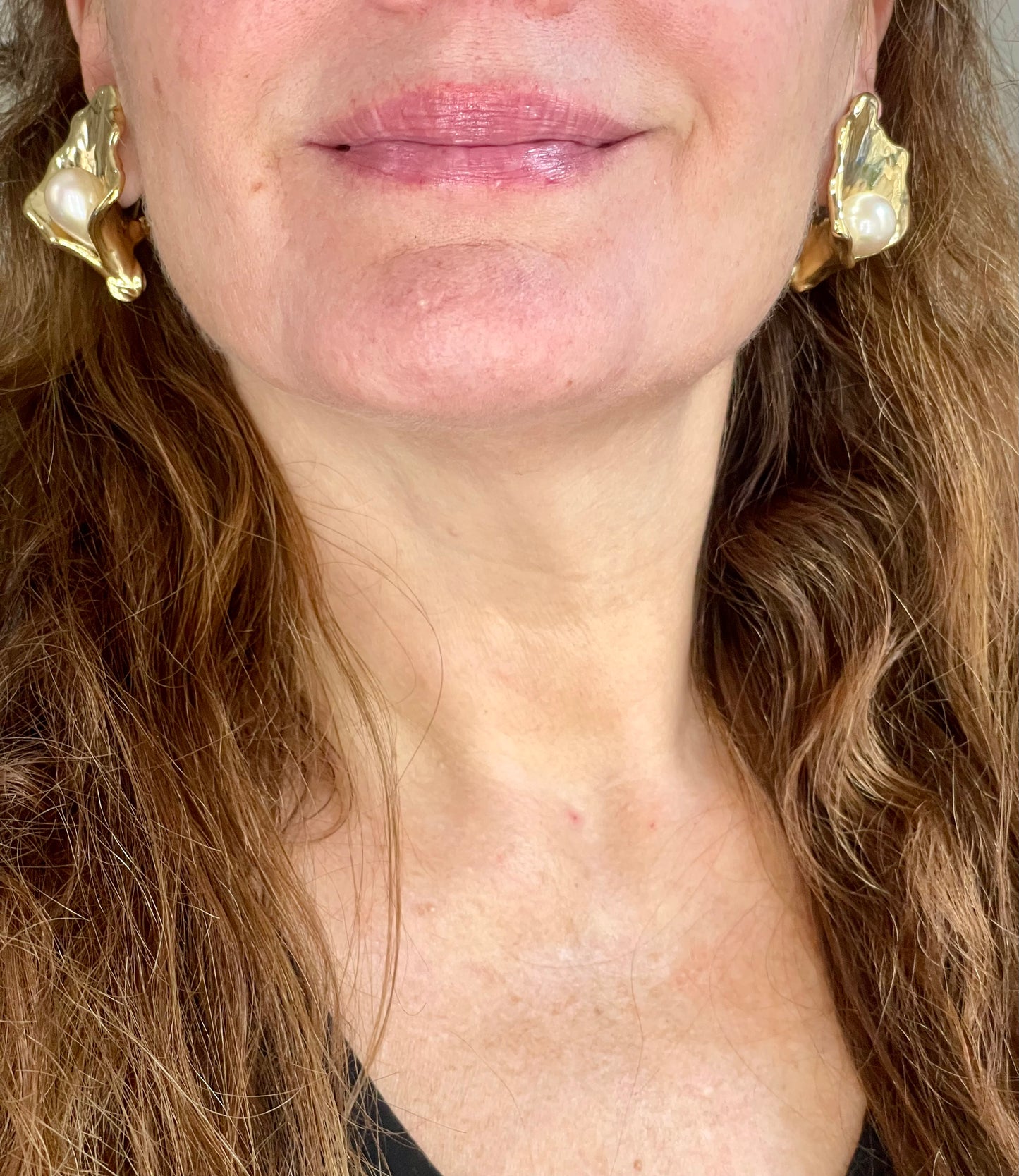 Close up on a model wearing Authentic vintage Yves Saint Laurent earrings, organic gold-tone flower design with pearl accents