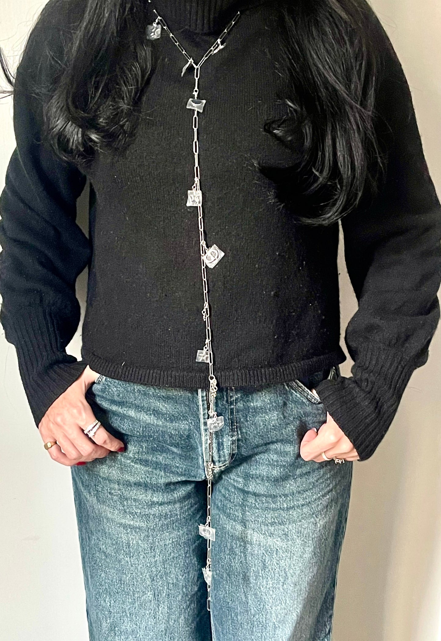 Front view worn by model as a very long necklace upcycled Dior Beauté phone charm necklace with removable silver-tone charms