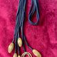 Art textile necklace with black fabric cords and gold tone pompom elements