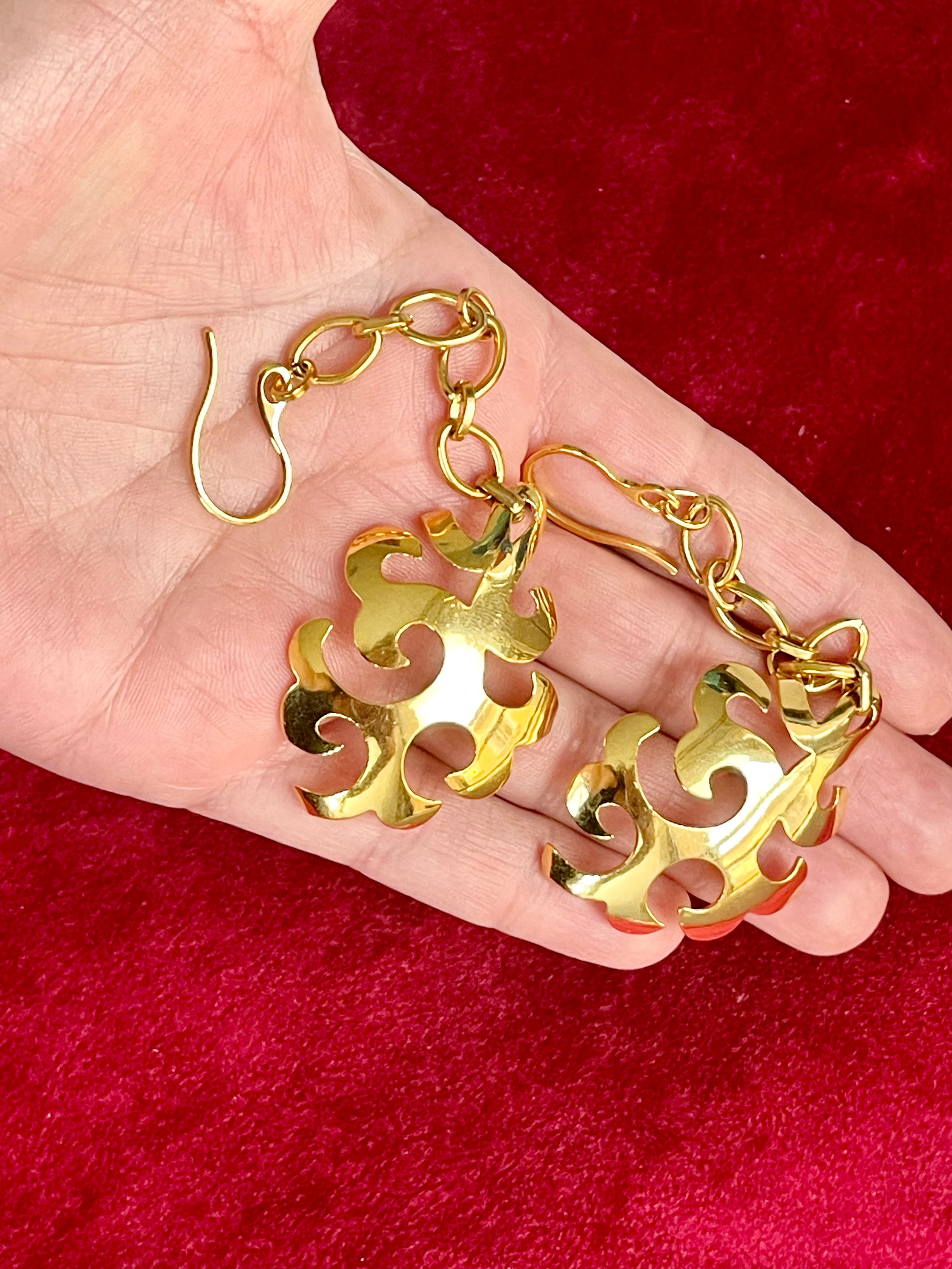 Vintage Yves Saint Laurent earrings displayed on hand to show size and weight