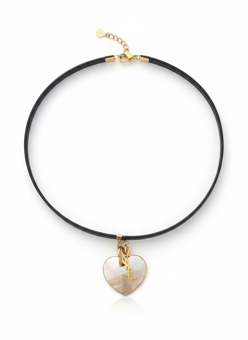 vintage Yves Saint Laurent heart seashell pendant YSL charm mounted on a black leather YSL Parfums necklace.