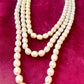 Vintage Yves Saint Laurent faux pearl statement necklace , showcasing multi-strand design and bold gold clasp at the neckline.