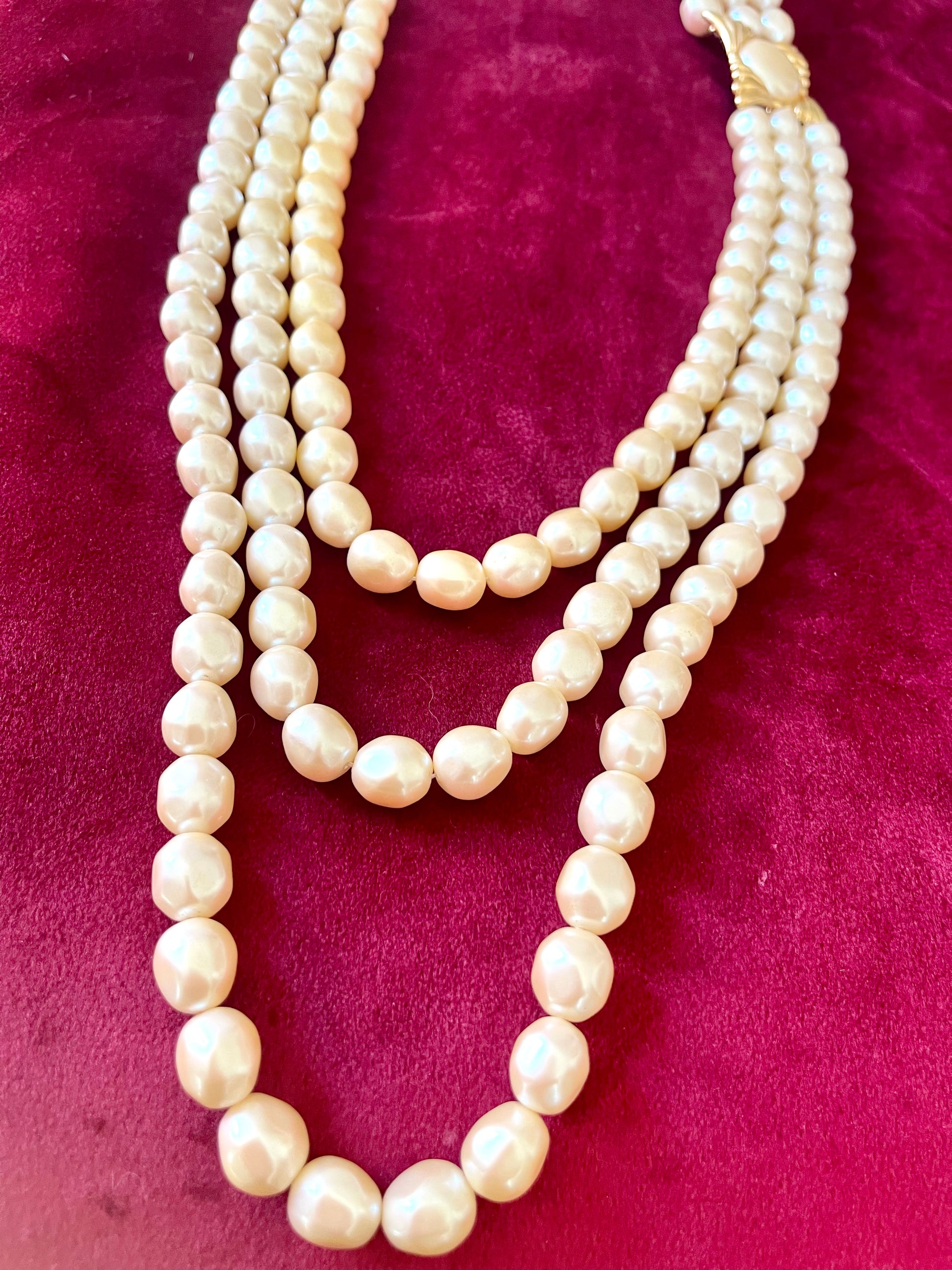 Vintage Yves Saint Laurent faux pearl statement necklace , showcasing multi-strand design and bold gold clasp at the neckline.