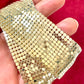 Close-up of pixel metal mesh texture reflecting light of Vintage Paco Rabanne belt 