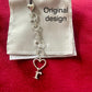 Dior phone charm original design, showing details close up with original pouch on red background 