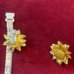 Orena Paris vintage gold sunflower-shaped earrings on a red background with a measuring tape 