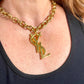 Worn by model Upcycled vintage Yves Saint Laurent gold-plated logo pendant on long stainless steel chain necklace showing different styles 