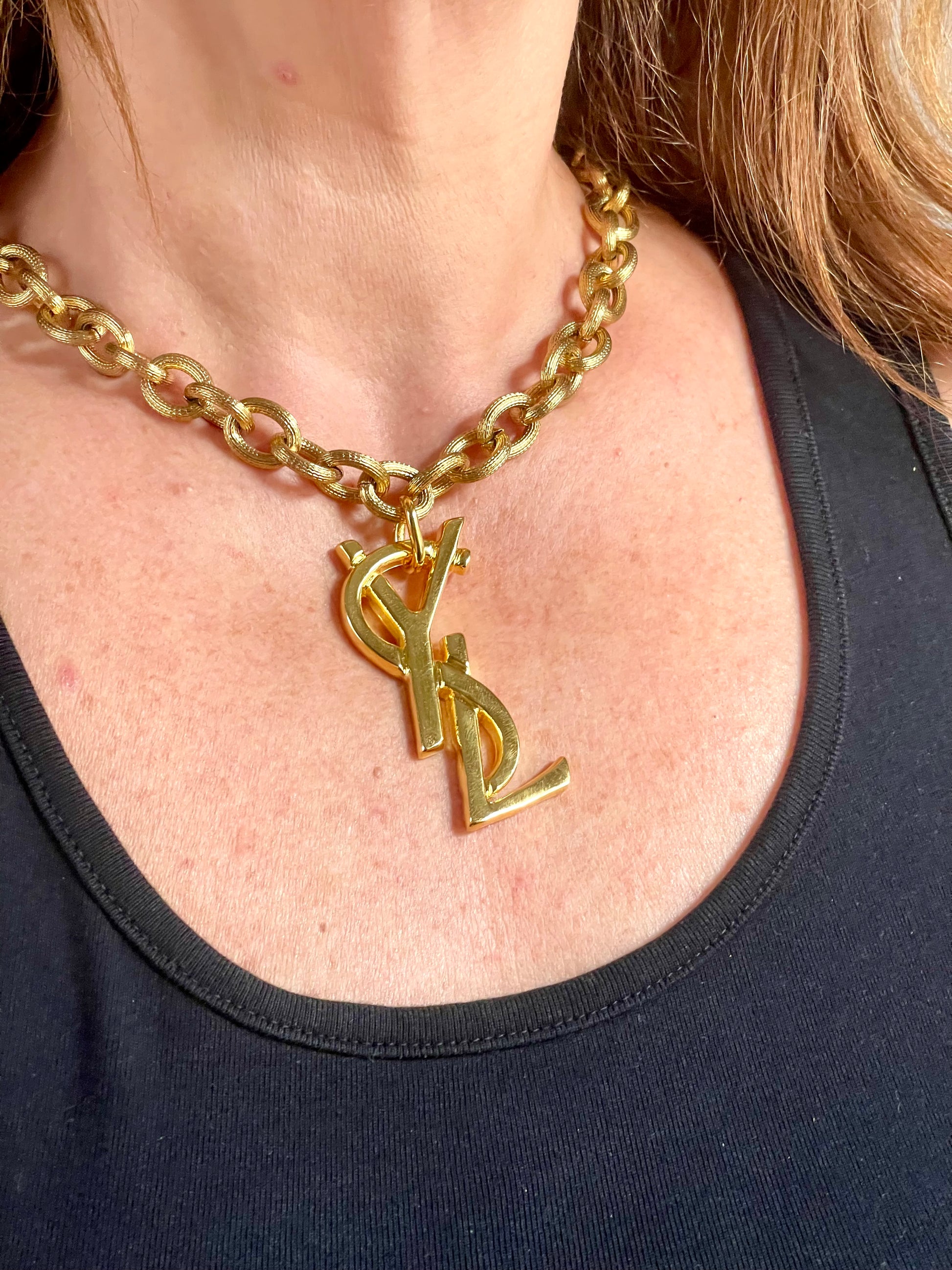 Worn by model Upcycled vintage Yves Saint Laurent gold-plated logo pendant on long stainless steel chain necklace showing different styles 
