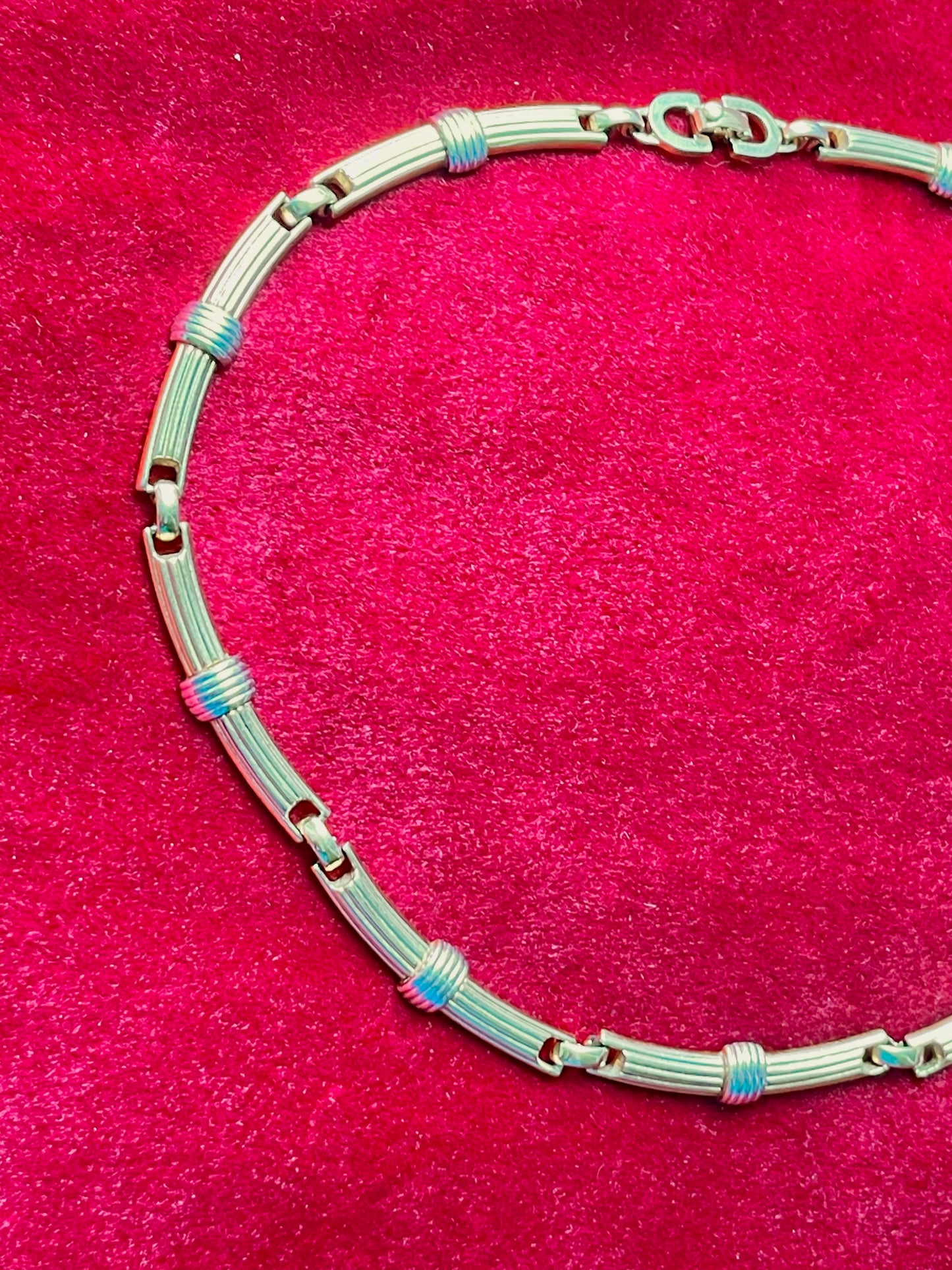 Vintage Christian Dior two-tone necklace with ribbed accents displayed on a red velvet background
