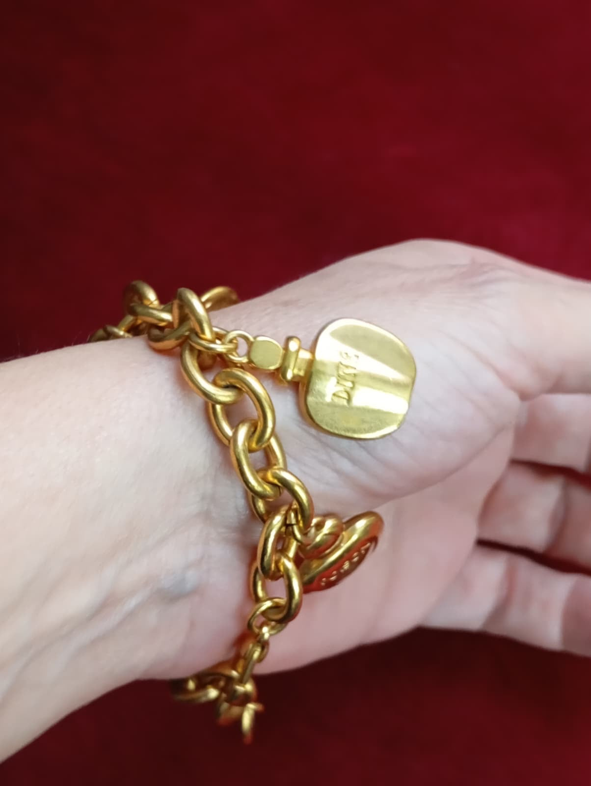 Close-up of Dior perfume bottle charms referencing Miss Dior, Poison, and Dolce Vita Worn on wrist