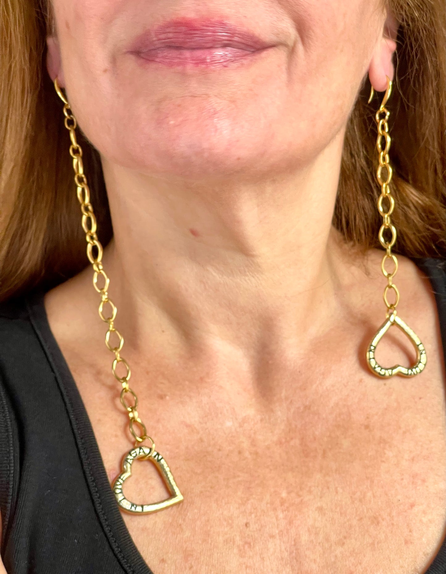 Detailed shot of YSL earrings worn, showing gold shine